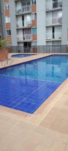 a large blue swimming pool in a building at Apartamento Amoblado Conjunto Terraverde in Ibagué