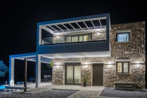 Cette maison moderne est décorée dans des tons bleus. dans l'établissement ELIA STONE VILLAS, à Skala Prinou