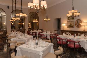 a restaurant with white tables and chairs and chandeliers at Hotel Plaza 79 in San Cristóbal de Las Casas