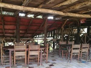 a group of tables and chairs in a building at Rancho paola in Cotuí
