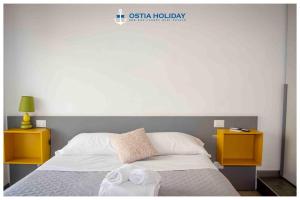 a bedroom with a bed with two nightstands and two towels at Sunset in Lido di Ostia