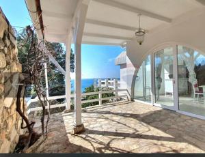 une maison avec une terrasse couverte offrant une vue sur l'océan dans l'établissement La grande bellezza, à Martinšćica