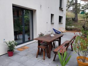 Une table et des chaises en bois sont disponibles sur la terrasse. dans l'établissement Lisière de la Forêt, à La Baule