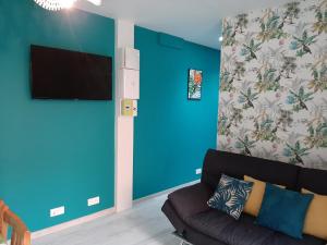 - un salon avec un canapé et un mur bleu dans l'établissement Lisière de la Forêt, à La Baule