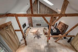 a living room with wooden beams and a room with a couch at 7 STODOŁA - Hotel butikowy in Osiek