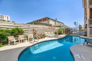a swimming pool with chairs next to a building at Bayfront condo with water view & boat slips! in South Padre Island