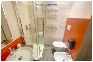 Un baño con ducha, lavabo e inodoro. en Ostia Holiday Sunset, en Lido di Ostia 5 fotos más
