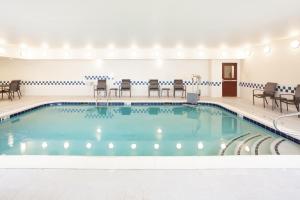 una piscina en una habitación de hotel con sillas y mesas en Fairfield Inn by Marriott North Little Rock, en North Little Rock