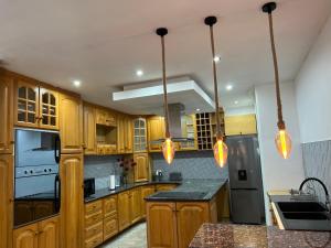 - une cuisine avec des placards en bois et des appareils bleus dans l'établissement Villa Le Rosa Unit 3, à Durban