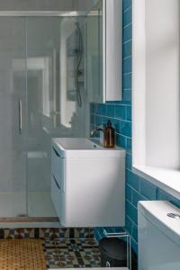 een badkamer met een wastafel en een douche bij Detached Luxury 6 beds, Super Wi-fi, easy parking and Hot-tub in Baildon