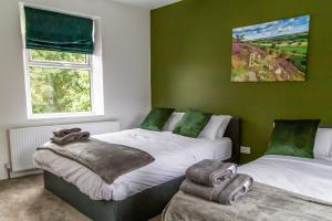 two beds in a room with green walls at Detached Luxury 6 beds, Super Wi-fi, easy parking and Hot-tub in Baildon