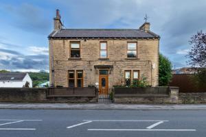 a brick house on the side of the street at Detached Luxury 6 beds, Super Wi-fi, easy parking and Hot-tub in Baildon