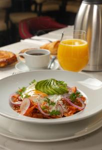 Ein Teller mit Essen und ein Glas Orangensaft auf einem Tisch. in der Unterkunft Hotel Plaza 79 in San Cristóbal de las Casas