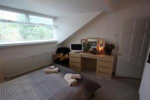 a bedroom with a bed and a desk with a computer at Lymm Village Apartment in Lymm