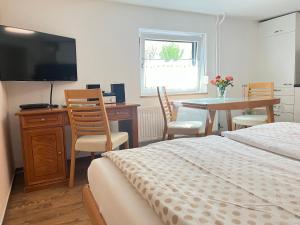 a bedroom with a bed and a desk and a table at Appartement Am Straßland in Kirchheim