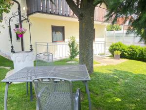a table and chairs sitting next to a tree at Appartement Am Straßland in Kirchheim