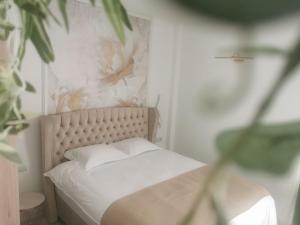 a bedroom with a white bed with a flower wallpaper at Vila AMAZON in Dubova