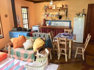 a kitchen with a couch and a table with chairs at RECANTO Do SOL VISCONDE DE MAUÁ in Visconde De Maua