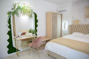 Schlafzimmer mit einem Bett, einem Schreibtisch und einem Spiegel in der Unterkunft Vila AMAZON in Dubova