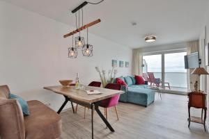 - un salon avec une table et un canapé dans l'établissement Haus Sommertraum Haus Sommertraum, Appartement 6 "Sonnendeck", à Haffkrug