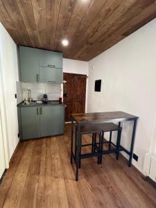 a kitchen with a wooden table in a room at Au cœur de la Cité Vauban in Briançon