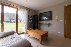 a living room with a couch and a tv and a table at La Résidence de Lorelei in Cierp