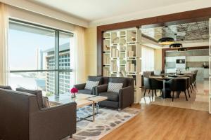 a living room with couches and a dining room at Le Méridien City Centre Bahrain in Manama