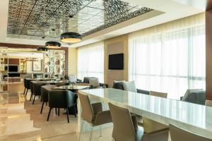 a conference room with tables and chairs and a television at Le Méridien City Centre Bahrain in Manama