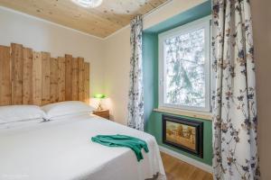 ein Schlafzimmer mit einem weißen Bett und einem Fenster in der Unterkunft B&B Cà Selvetta in Forcola