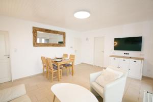a living room with a table and a chair at Ferienhaus Albatrosstr 36 Ostermann Bungalow 2 in Norddeich