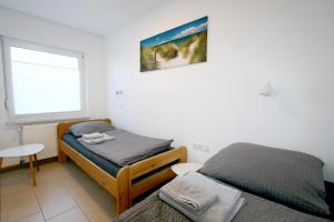 a bedroom with two twin beds and a window at Ferienhaus Albatrosstr 36 Ostermann Bungalow 2 in Norddeich
