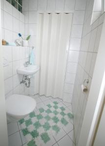 a white bathroom with a sink and a toilet at Ferienhaus Albatrosstr 36 Ostermann Bungalow 2 in Norddeich +9 photos