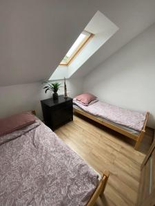 a attic bedroom with two beds and a skylight at Noclegi Grojec 