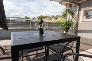 een zwarte tafel met twee glazen en een fles wijn bij Appartement Gamlitz in Gamlitz