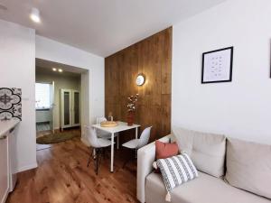 a living room with a white couch and a table at Bytom Kwietniewskiego Studio 1 with sofa bed in Bytom