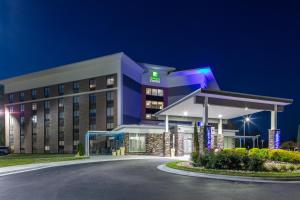 um edifício de hotel com posto de gasolina à noite em Holiday Inn Express - Rocky Mount - Sports Center, an IHG Hotel em Rocky Mount