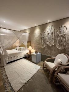 a bedroom with a canopy bed and a white rug at Hotel da Pipa in Pipa