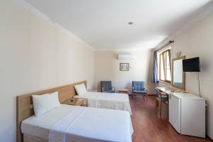 アンタルヤにあるŞehir Hotelのベッド2台、テーブルと椅子が備わるホテルルームです。