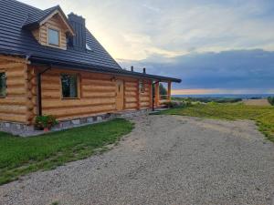 ein Blockhaus mit einer Kieseinfahrt davor in der Unterkunft Dylewska Widokówka in Pietrzwałd