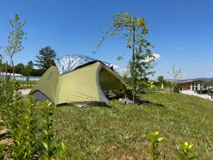 una tenda seduta sull'erba in un campo di 7 Lakes camping a Sapareva Banya