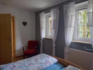 a bedroom with a bed and a window and a chair at Bernsteinglück in Wunsiedel