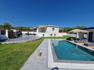 a backyard with a swimming pool and a house at Villa Hillside Pefkohori in Pefkochori