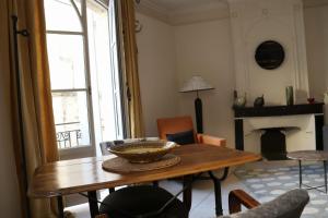a living room with a table and a fireplace at Uzès Centre Quartiers des Arts Charme de l'ancien in Uzès