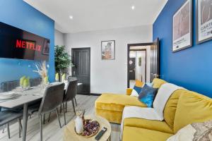 a living room with a yellow couch and a table at Exquisite 4 bed in Leeds - Sleeps 10 - Parking in Leeds
