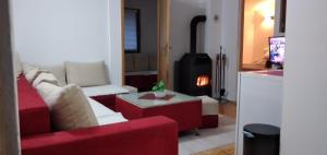 a living room with a red couch and a fire place at Farah House in Sarajevo