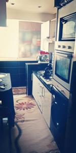 a kitchen with a stove and a microwave at شقة مجهزة للكراء في فرح السلام الألفة in Casablanca