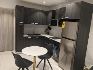 uma cozinha com uma mesa, um frigorífico e cadeiras em Lennox by Cush Realty em Acra