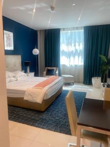 a bedroom with a bed and a blue wall at Квартира студия Damac Maison Cour Jardin in Dubai
