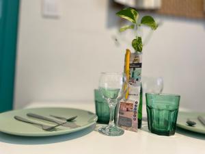 een tafel met een bord en glazen en een plant bij L'Appart & verte à l Arbresle in LʼArbresle