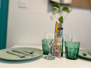 une table avec une assiette, des verres et une plante dans l'établissement L'Appart & verte à l Arbresle, à LʼArbresle